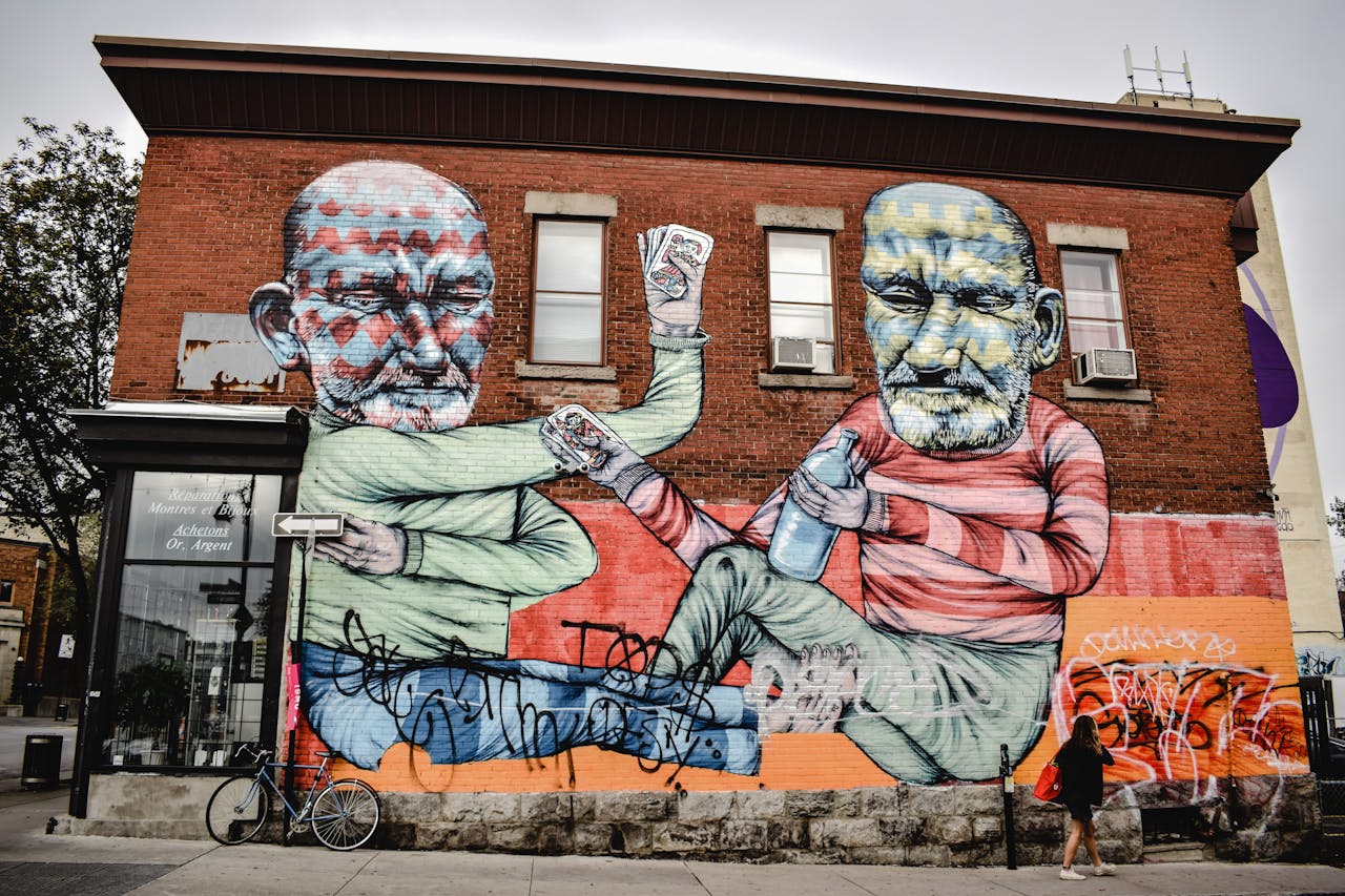 Contact Colorful mural artwork on a brick wall in Montreal, showcasing bold street art.